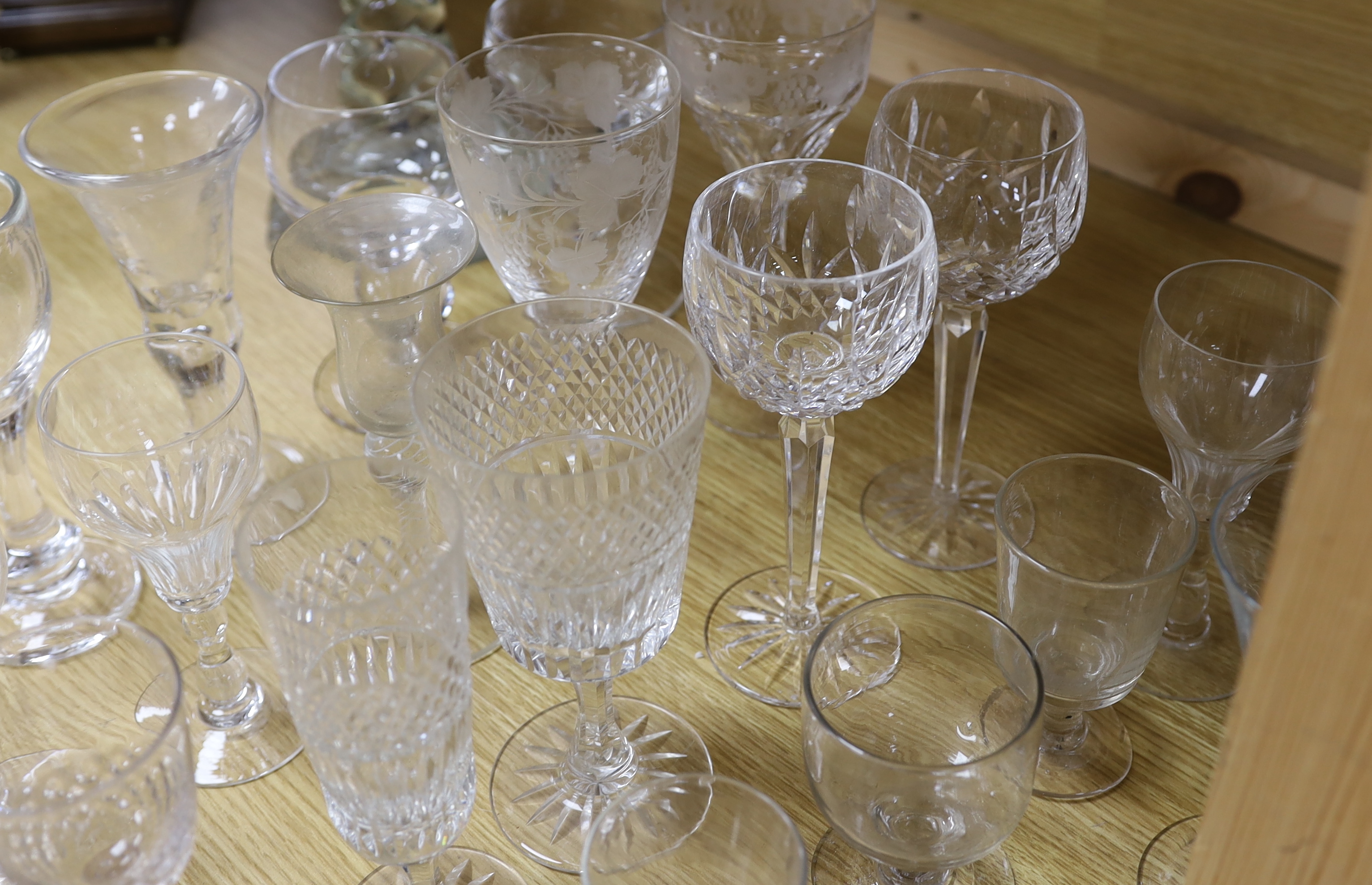 A large glass centrepiece, a teardrop trumpet shaped vase and a collection of 19th and 20th century wine and other drinking glasses